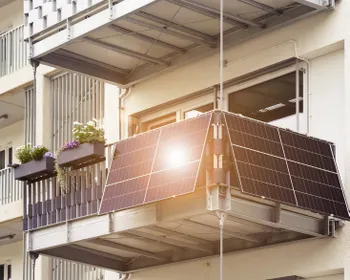 Eine Mini PV-Anlage auf dem Balkon einer Wohnung, auf der sich die Sonne spiegelt