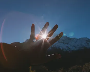 Jemand hält die Hand vor die Sonne