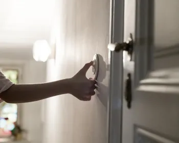 Man sieht eine Hand, die einen Lichtschalter betätigt.