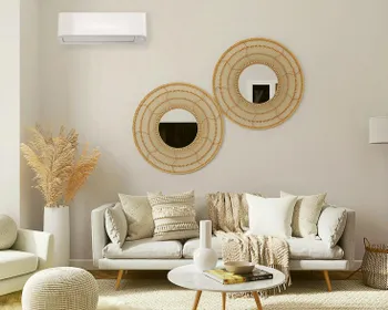 Bohostil eingerichtetes Wohnzimmer mit Couch und einer Klimaanlage an der Wand