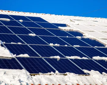 Schnee bedeckt teilweise eine Photovoltaik-Anlage