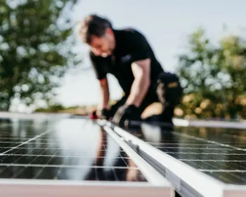 Mann montiert eine PV Anlage.