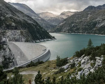 Stausee in dramatischer Berglandschaft.