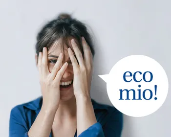 Frau lächelt und verdeckt ihr Gesicht mit ihren Händen. Sprechblase mit dem Text EcoMio.