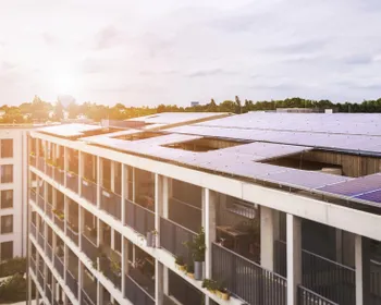 Ein Mehrparteienhaus mit PV Paneelen am Dach.