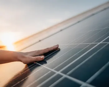 Eine Hand streicht über eine PV-Anlage