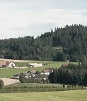 Eine Landschaft mit Feldern und Häusern unter blauem Himmel