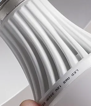 Eine Glühbirne wird in eine Lampe geschraubt.