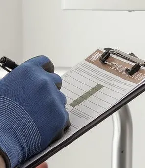 Installationsfachkraft bei der Thermenwartung mit Clipboard
