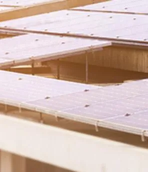 Ein Mehrparteienhaus mit PV Paneelen am Dach.