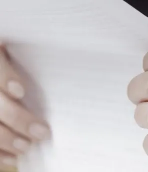 Ein Pärchen sitzt zusammen und hält mehrere Dokument in der Hand.