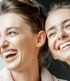 Zwei junge Frauen lachen und genießen ihren SPA-Tag.